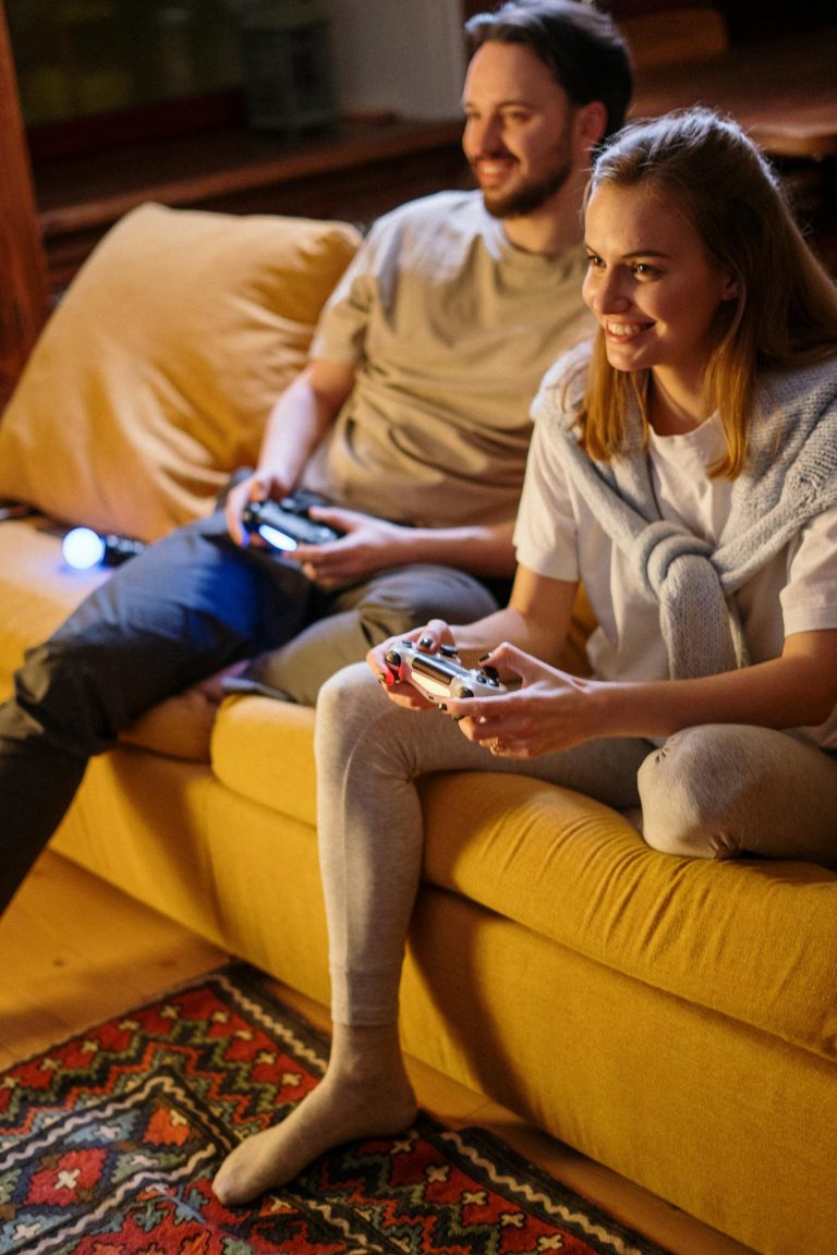 A cheerful couple gaming together at home on a comfortable sofa, creating warm and joyful moments.