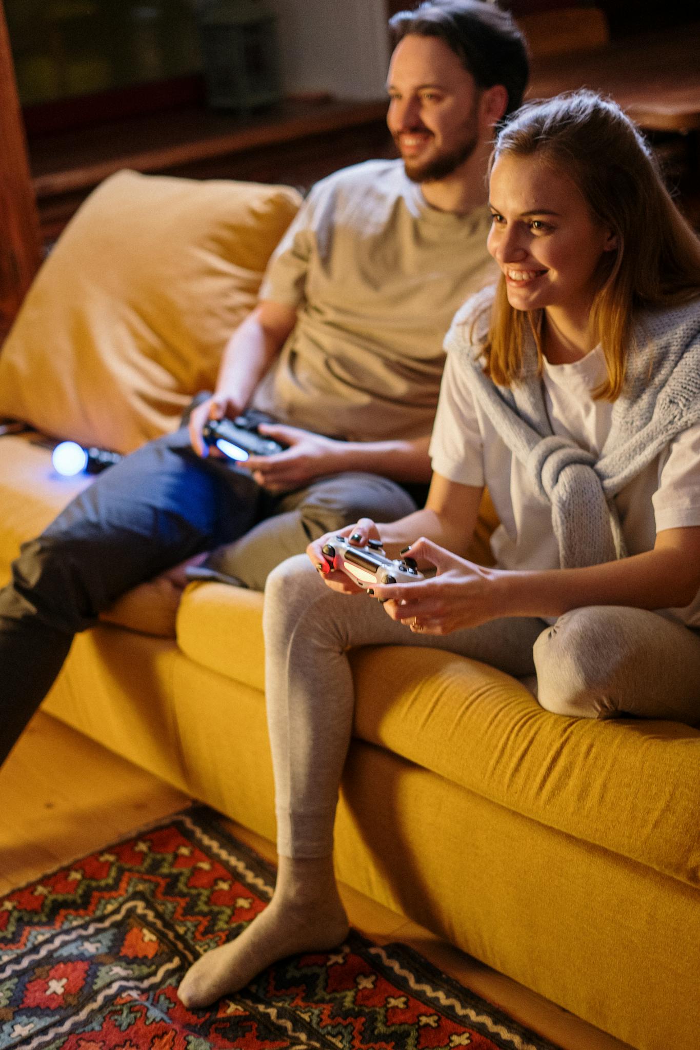 A cheerful couple gaming together at home on a comfortable sofa, creating warm and joyful moments.