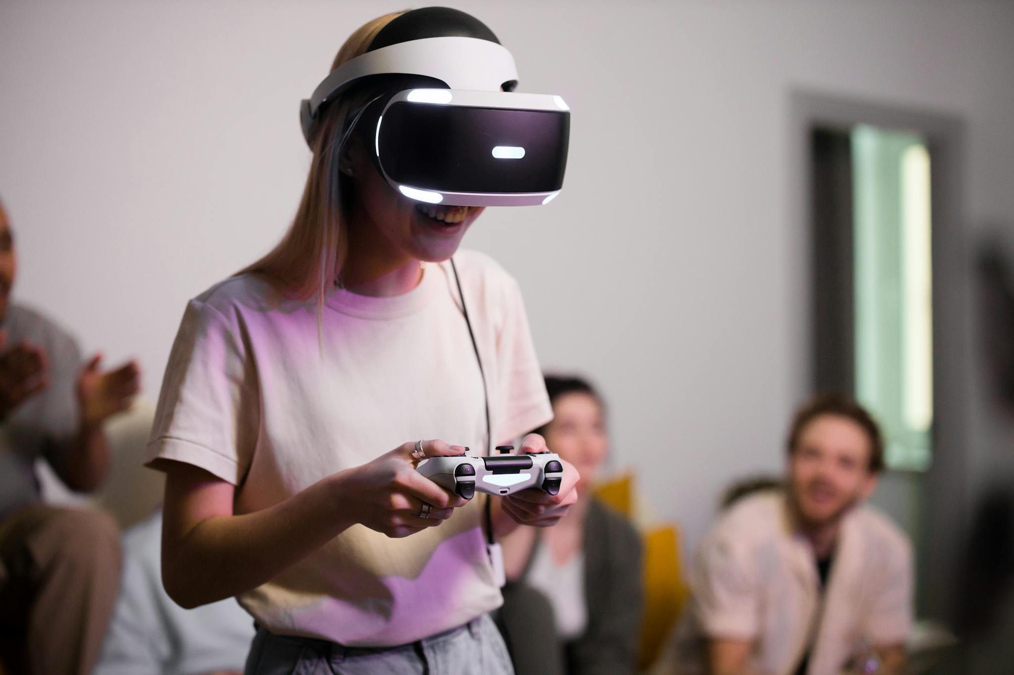 Woman wearing a VR headset and holding a controller, smiling during a casual gaming session with friends