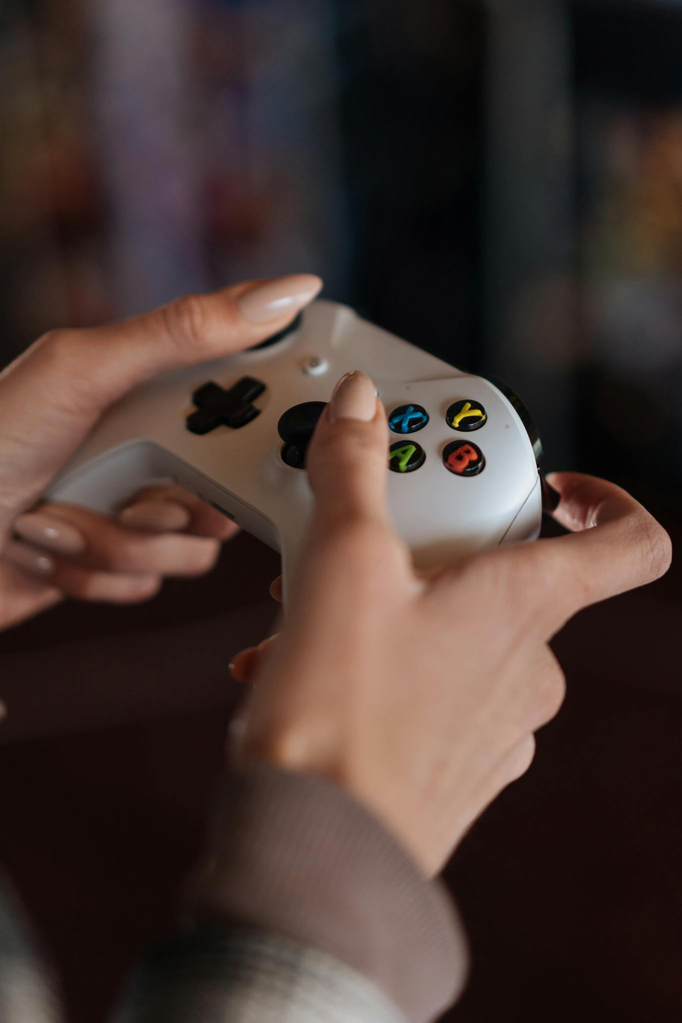 Adult gamer sitting casually while holding a PlayStation controller indoors